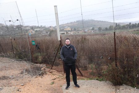 בודק גבולות. כתב משפחה ומאחוריו בתי הכפר הלבנוני אל-כילה